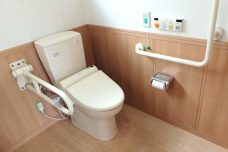 温温便座付きトイレと木調の壁パネルの清潔なトイレ室